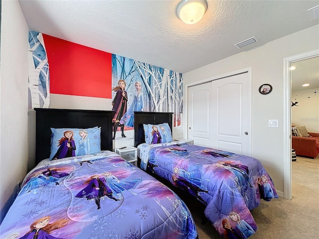 bedroom with a closet, a textured ceiling, and carpet