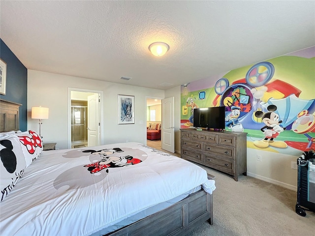 carpeted bedroom featuring ensuite bath and a textured ceiling