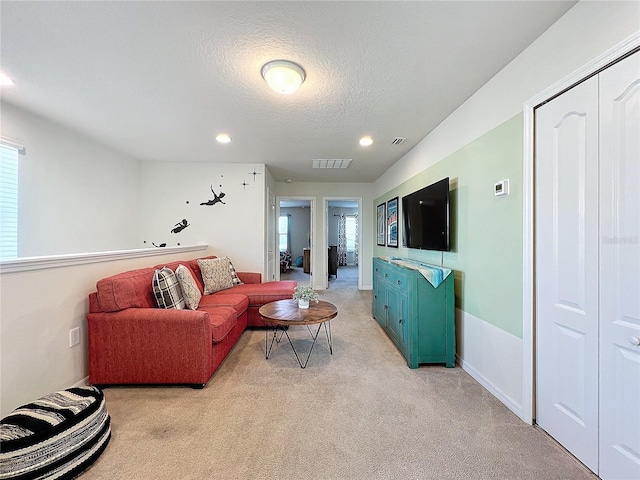 carpeted living room featuring a textured ceiling