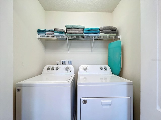 clothes washing area with a textured ceiling and separate washer and dryer