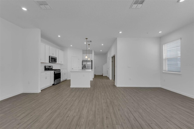 kitchen with white cabinetry, hanging light fixtures, light hardwood / wood-style flooring, appliances with stainless steel finishes, and a kitchen island