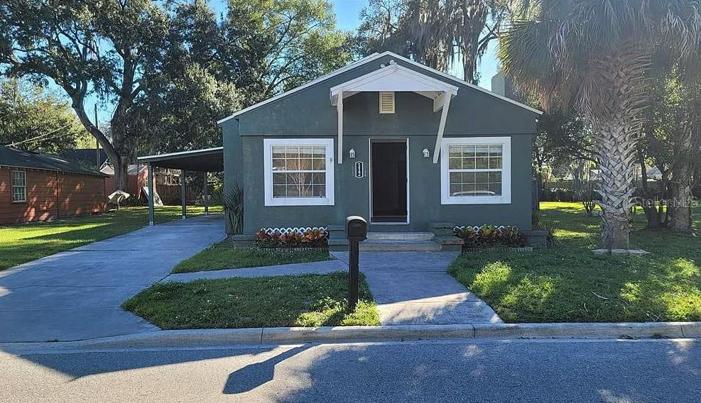 bungalow-style home with a carport and a front yard