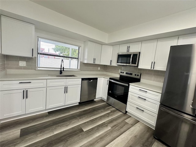 kitchen with stainless steel appliances, light countertops, a sink, dark wood-type flooring, and white cabinetry