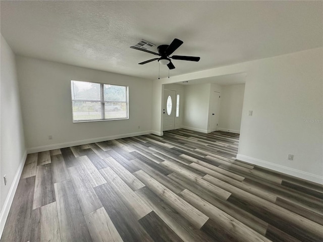 unfurnished room with wood finished floors, a textured ceiling, baseboards, and ceiling fan
