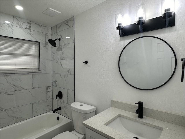 full bathroom featuring toilet, tiled shower / bath combo, vanity, and a textured ceiling