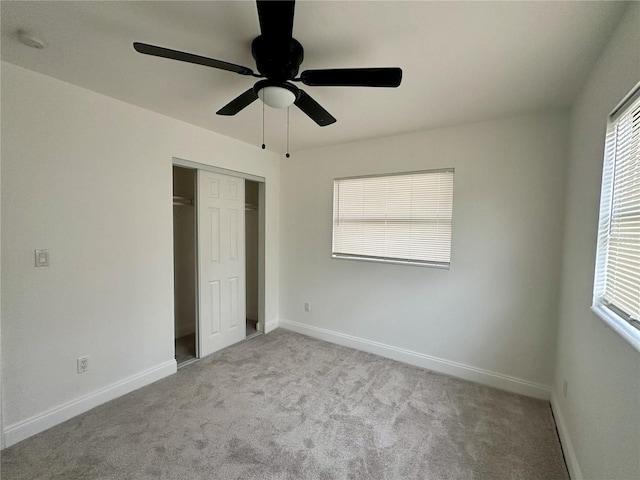 unfurnished bedroom with light carpet, a closet, and ceiling fan