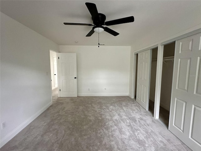 unfurnished bedroom featuring two closets, carpet, and ceiling fan