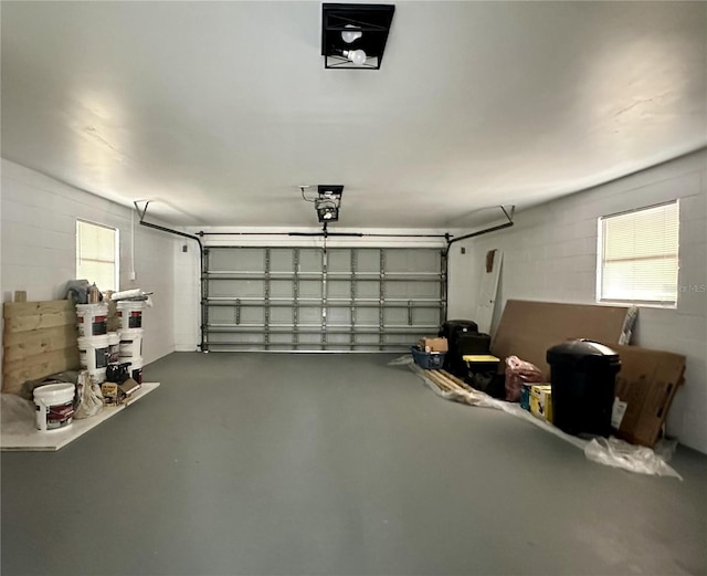 garage featuring concrete block wall and a garage door opener