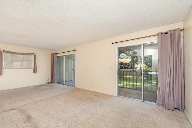 carpeted spare room with a textured ceiling