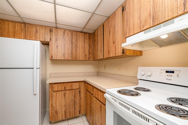 kitchen featuring extractor fan, light tile patterned floors, and white appliances