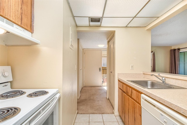 kitchen featuring a textured ceiling, exhaust hood, sink, white appliances, and light colored carpet