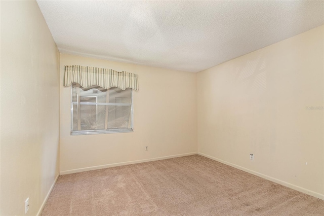 unfurnished room featuring a textured ceiling and light carpet