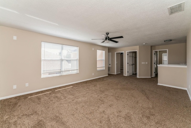 unfurnished room with a textured ceiling, carpet flooring, and ceiling fan