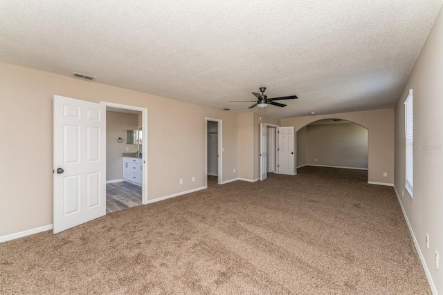 carpeted empty room with a textured ceiling and ceiling fan