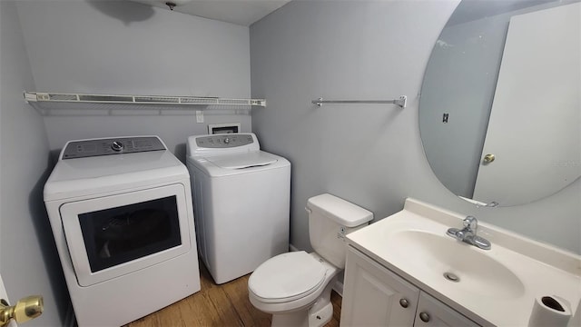 bathroom featuring vanity, toilet, washing machine and dryer, and wood-type flooring