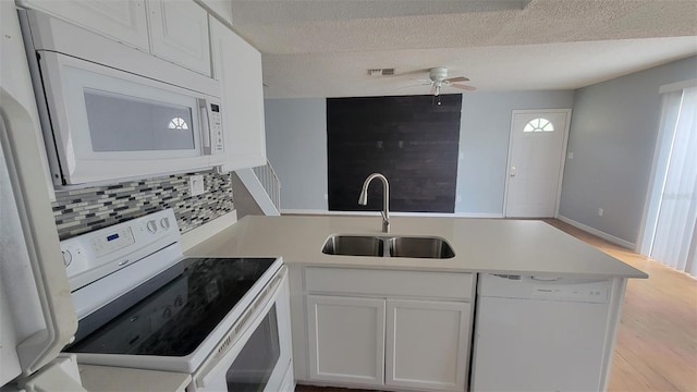 kitchen featuring white appliances, sink, kitchen peninsula, white cabinets, and light hardwood / wood-style flooring