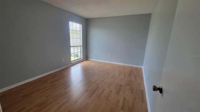 empty room featuring light hardwood / wood-style floors and a textured ceiling