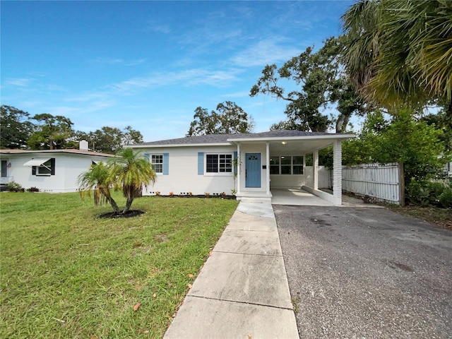 view of front of home with a front yard and a carport