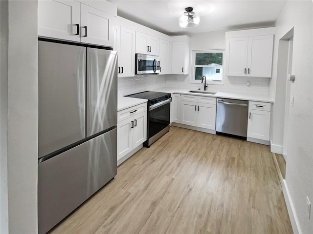 kitchen featuring sink, appliances with stainless steel finishes, light wood-type flooring, and white cabinets