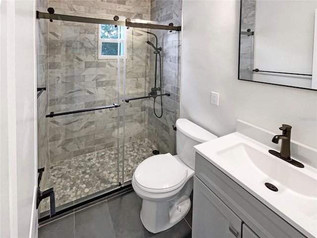 bathroom featuring vanity, toilet, tile patterned floors, and walk in shower