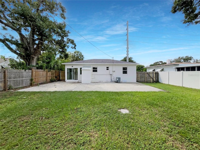 rear view of property with a patio, cooling unit, and a lawn