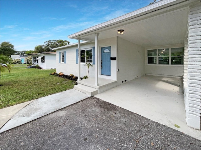 entrance to property featuring a lawn