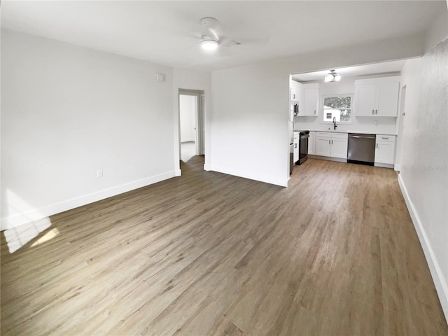 unfurnished living room featuring sink, hardwood / wood-style floors, and ceiling fan