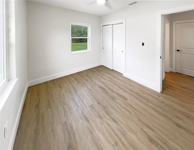 unfurnished bedroom featuring a closet, ceiling fan, and light wood-type flooring