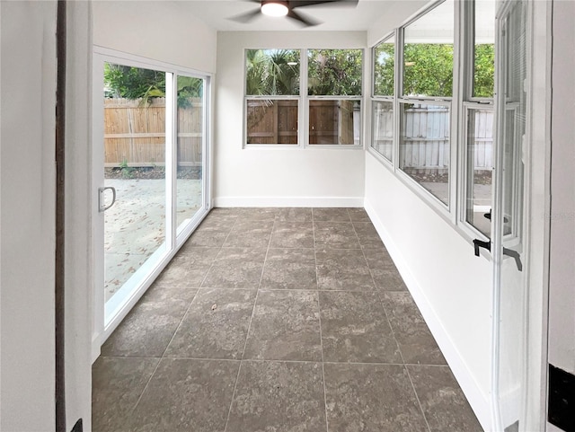 unfurnished sunroom featuring ceiling fan