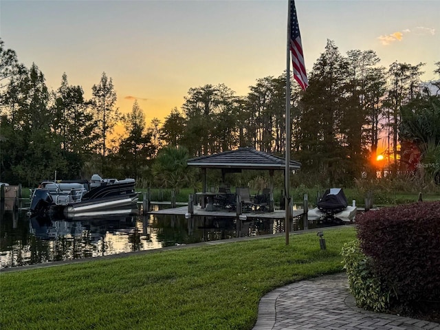 dock area with a water view and a lawn