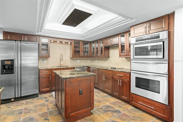 8984 Houston Pl Unit 103, Orlando, FL 32819 - kitchen with stainless steel appliances, a tray ceiling, a warming drawer, and stone finish floors