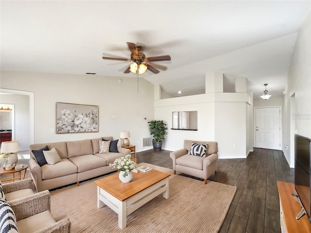 living room with dark hardwood / wood-style flooring, ceiling fan, and vaulted ceiling