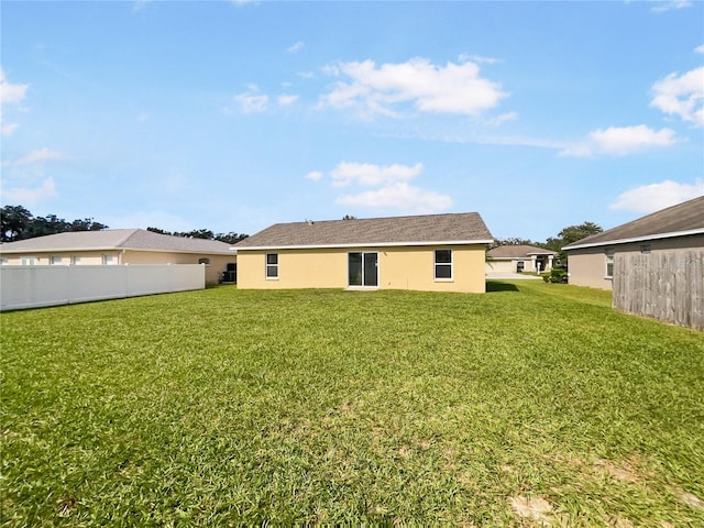 rear view of property featuring a lawn