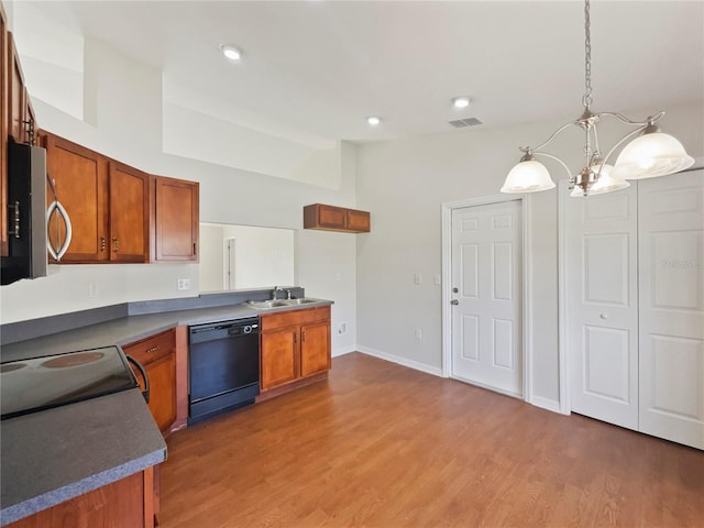 kitchen featuring black dishwasher, a chandelier, dark hardwood / wood-style floors, sink, and decorative light fixtures