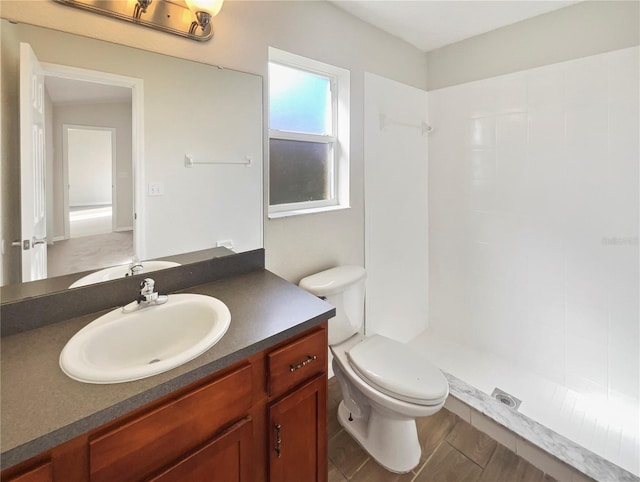 bathroom with vanity, a shower, and toilet