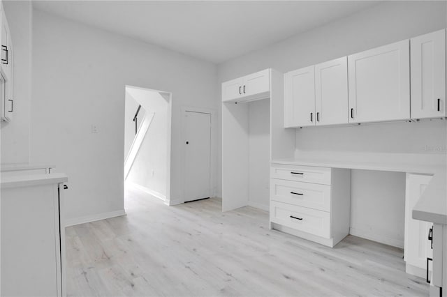 interior space featuring built in desk and light wood-type flooring