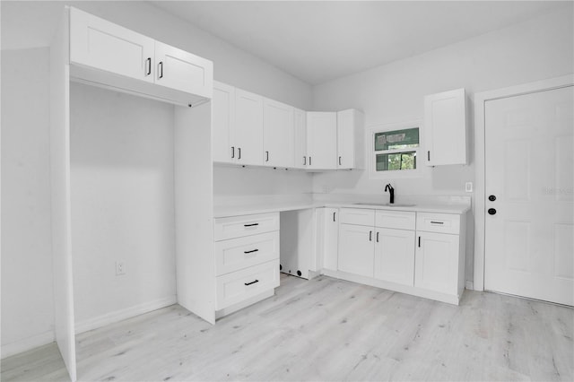 kitchen featuring light hardwood / wood-style floors, white cabinetry, and sink