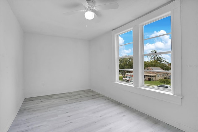 unfurnished room with light hardwood / wood-style floors, a wealth of natural light, and ceiling fan