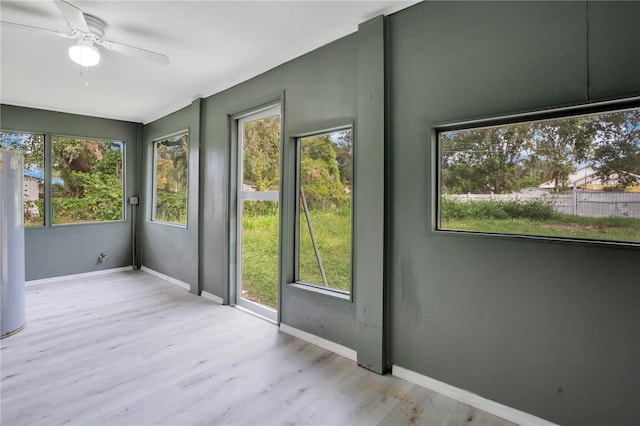 unfurnished sunroom with ceiling fan and a wealth of natural light