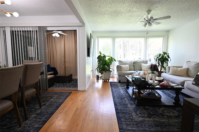 living room with ceiling fan, hardwood / wood-style flooring, and a textured ceiling