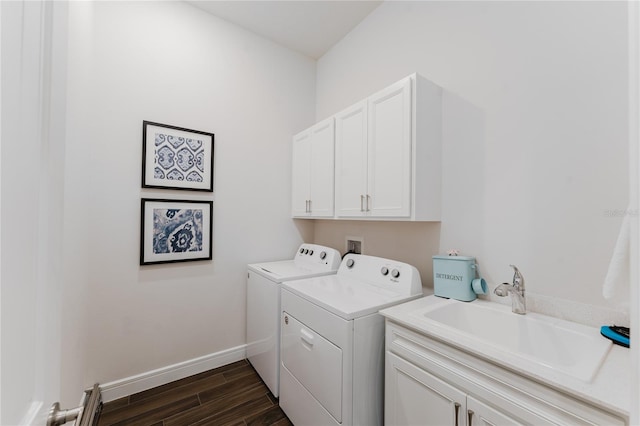 laundry area with sink, dark wood-type flooring, washer and clothes dryer, and cabinets