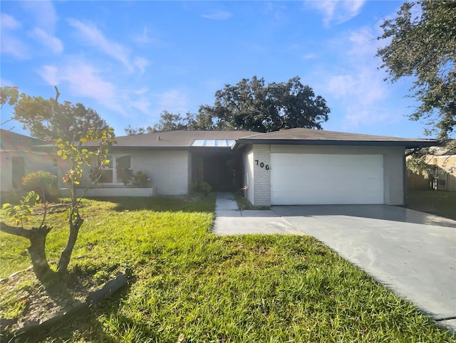 ranch-style home with a garage and a front lawn