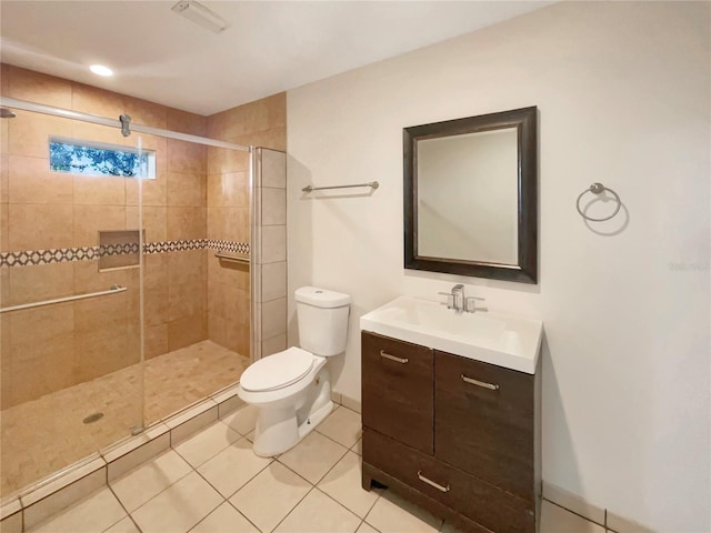 bathroom with toilet, tile patterned flooring, vanity, and a shower with door