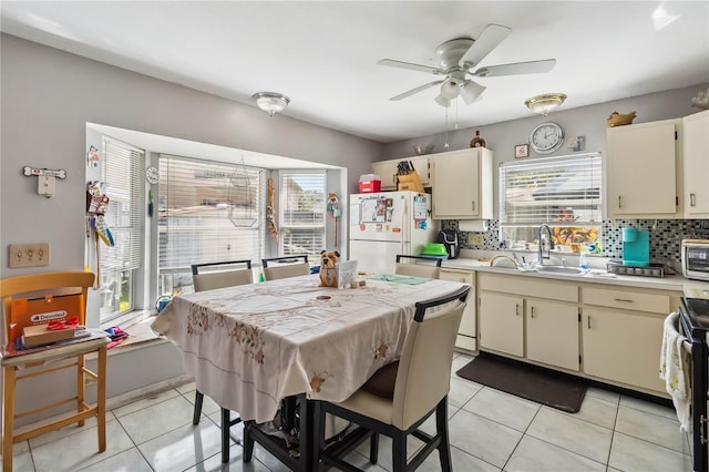 kitchen with cream cabinetry, a wealth of natural light, and white refrigerator