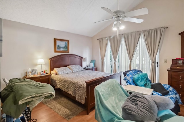 bedroom with light hardwood / wood-style floors, lofted ceiling, a textured ceiling, and ceiling fan