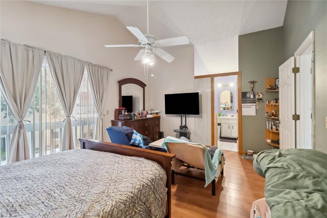 bedroom with access to exterior, ensuite bath, vaulted ceiling, light wood-type flooring, and ceiling fan