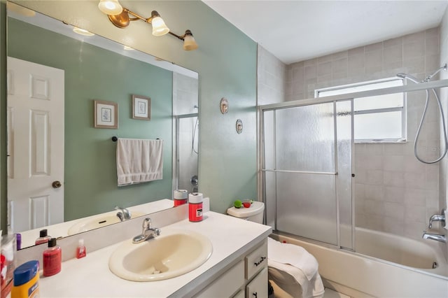 full bathroom featuring vanity, enclosed tub / shower combo, and toilet