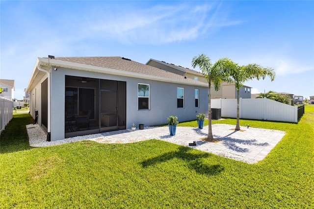 rear view of house featuring a patio, a lawn, cooling unit, and a sunroom