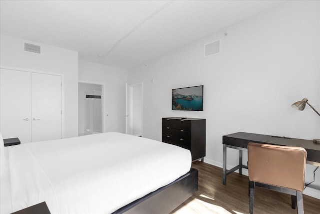 bedroom with dark wood-type flooring and a closet