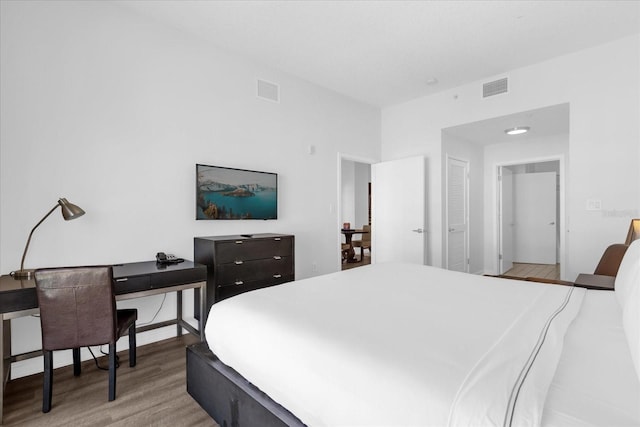 bedroom with light hardwood / wood-style floors and a closet